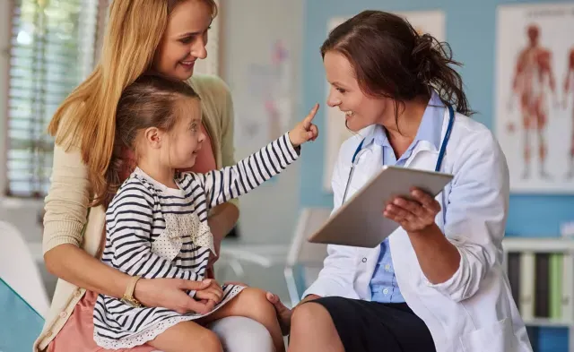 Pediatric Nurse Practitioner Smiling with Young Patient During Exam